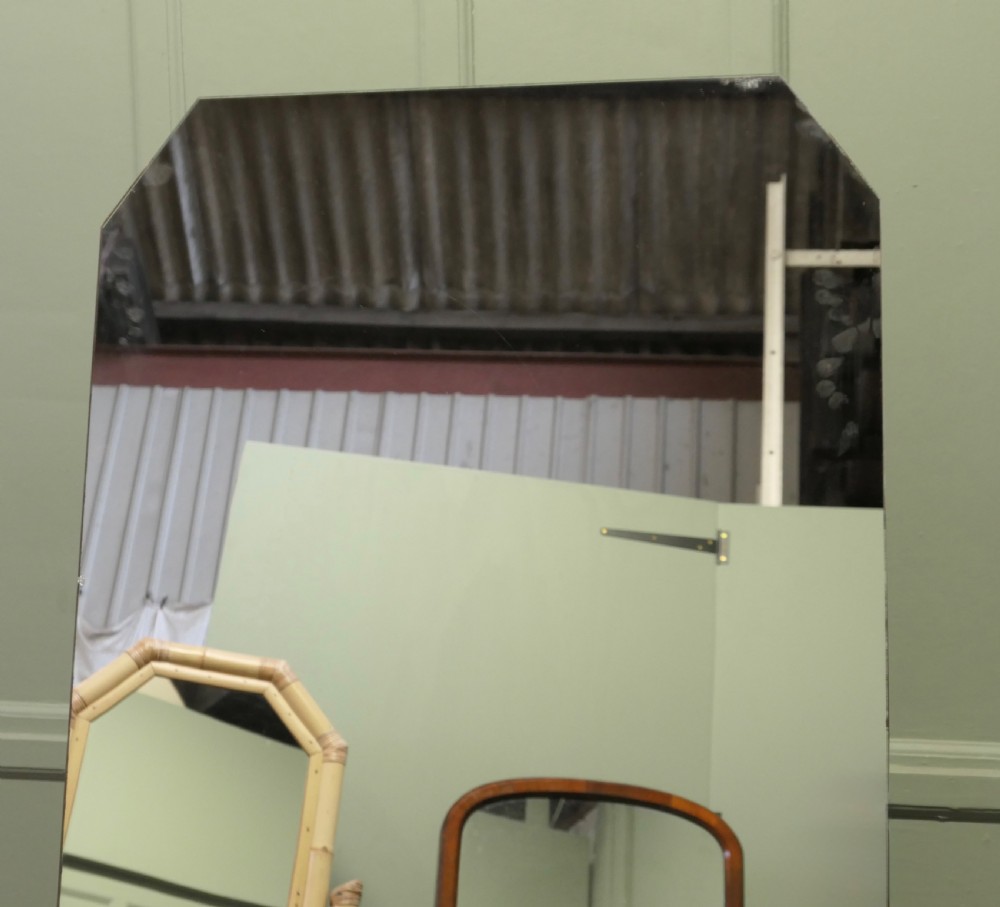 A tall Art Deco full-length cheval dressing mirror with clipped upper corners set within a dark timber frame supported by an easel stand. View V