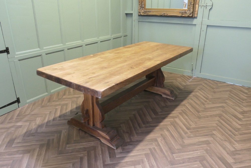 A large French oak monastery dining table featuring a thick rectangular plank top supported by heavy trestle end legs and a pegged stretcher. View II