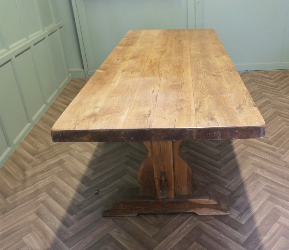 A large French oak monastery dining table featuring a thick rectangular plank top supported by heavy trestle end legs and a pegged stretcher. View III