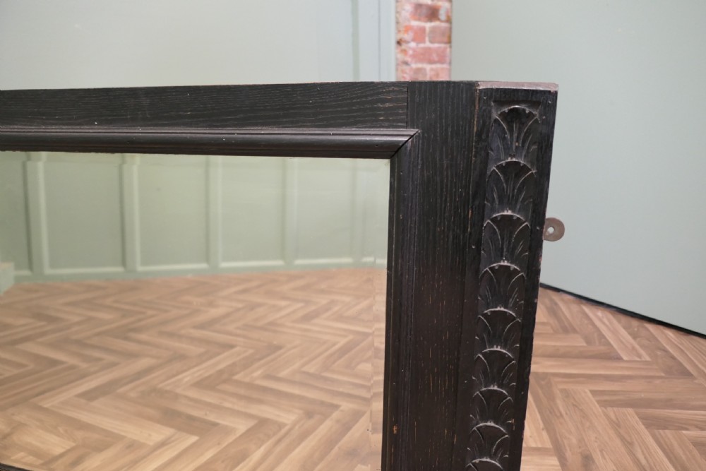 A large nineteenth-century rectangular mirror featuring a dark stained oak frame with carved foliate borders along the vertical sides. View II