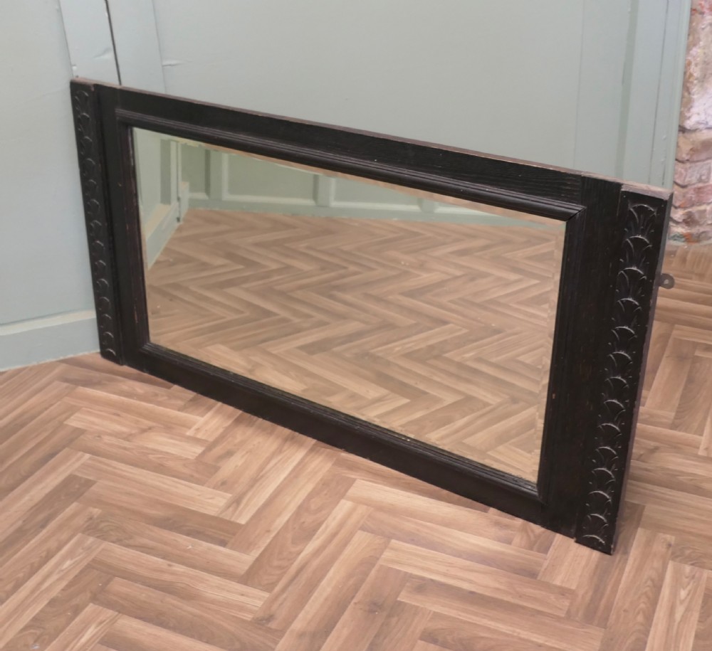 A large nineteenth-century rectangular mirror featuring a dark stained oak frame with carved foliate borders along the vertical sides. View V