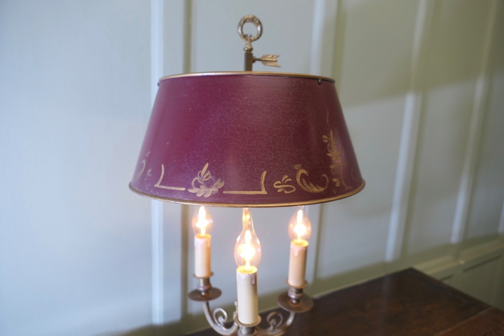 A French toleware and brass desk lamp featuring a burgundy lacquered shade with gilt floral painting and three candle-style light sockets. View II