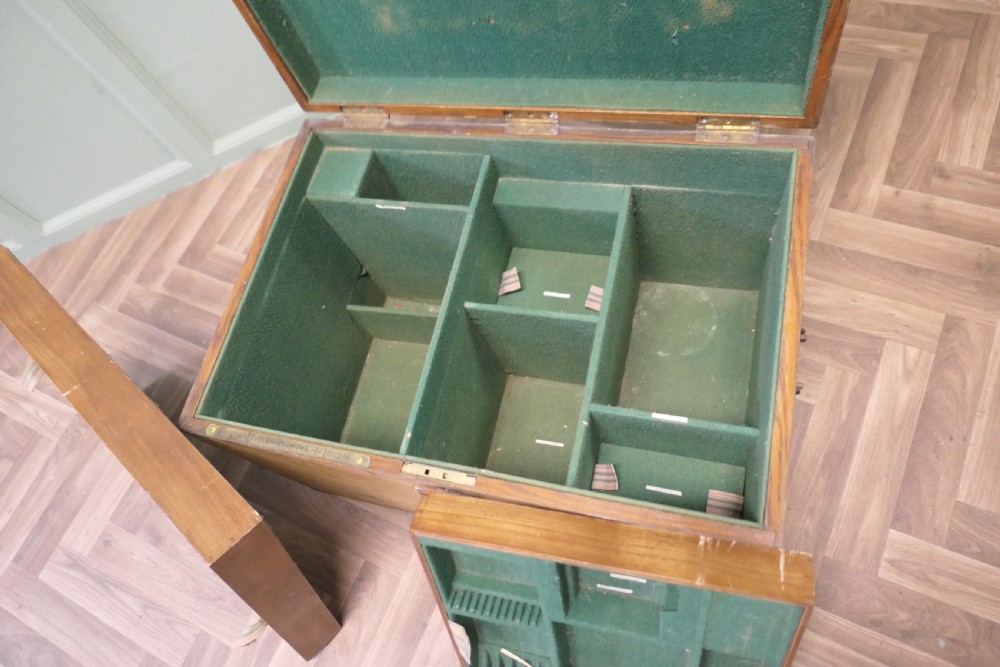A rectangular golden oak travelling silver chest featuring a hinged lid and central iron locking latch. View V