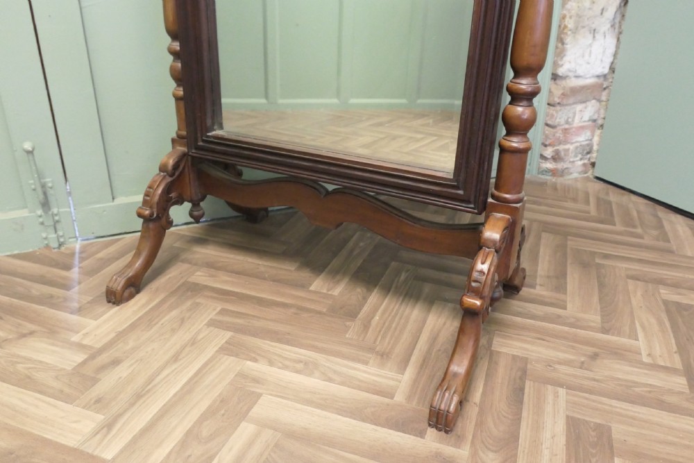 A Victorian carved mahogany cheval dressing mirror with an arched cresting top frame and turned side columns on splayed legs. View III