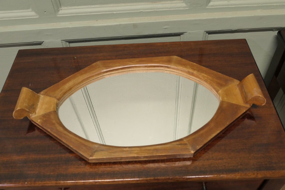An octagonal wooden Art Deco mirror tray featuring carved scroll side handles and a central glass insert. View V