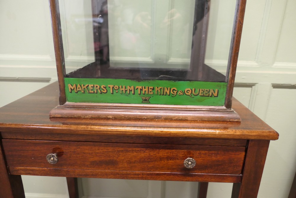 An Edwardian mahogany and glass countertop display cabinet featuring green advertising panels with gold Frys Chocolate lettering. View II