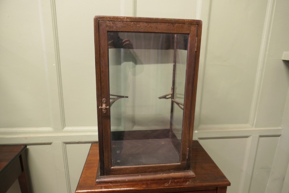 An Edwardian mahogany and glass countertop display cabinet featuring green advertising panels with gold Frys Chocolate lettering. View III
