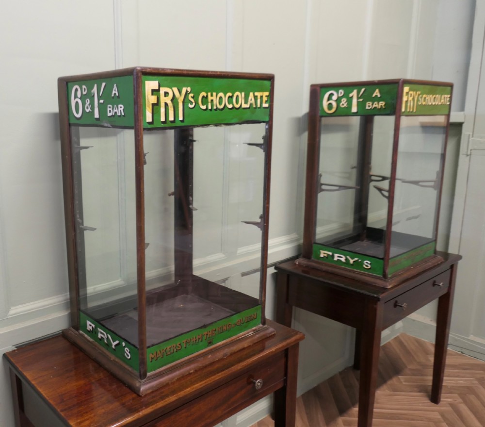 An Edwardian mahogany and glass countertop display cabinet featuring green advertising panels with gold Frys Chocolate lettering. View VI