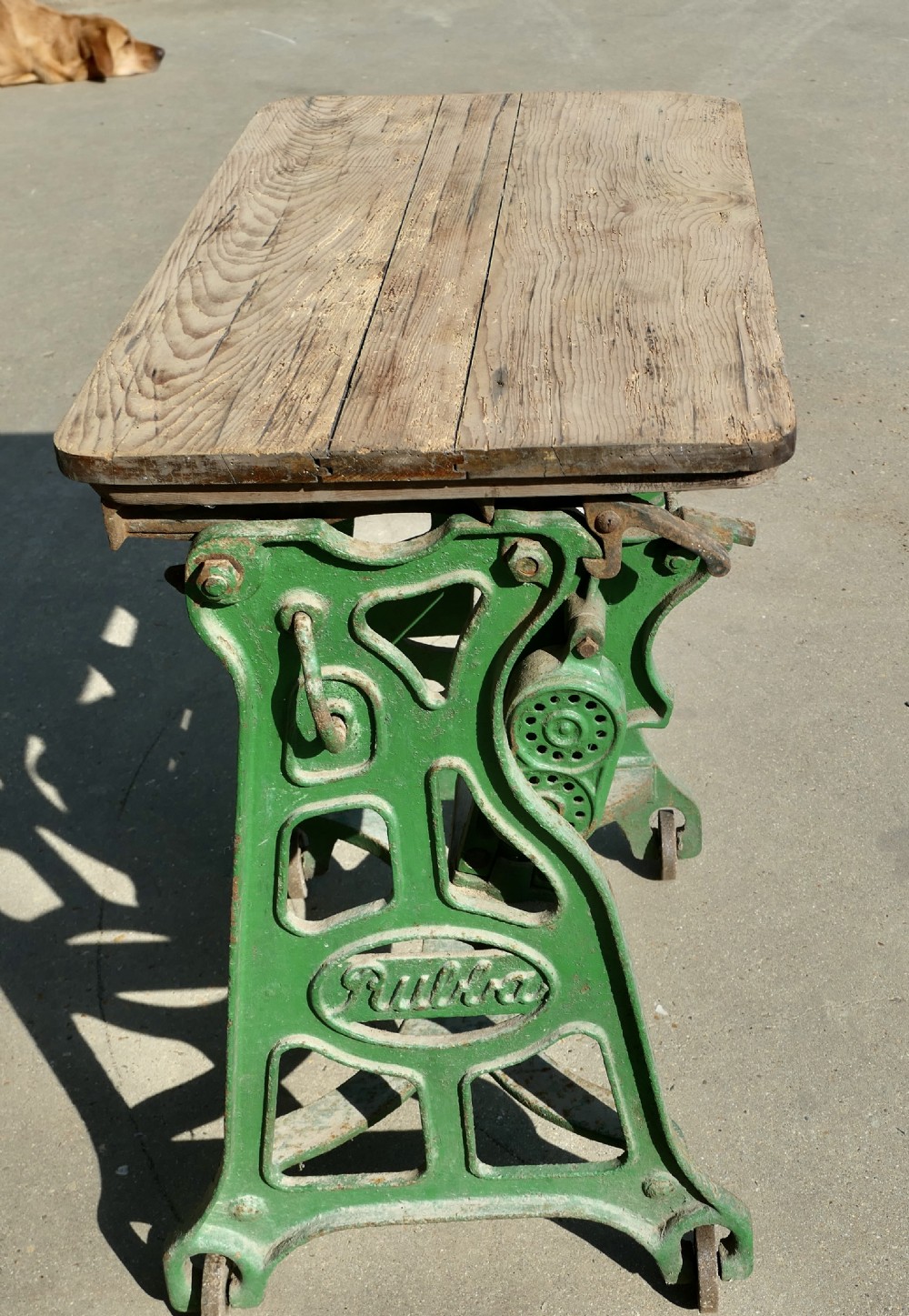 A green painted cast-iron mangle featuring an embossed Fulda logo, iron wheels, tension screws, and a hinged wooden pine top. View IV