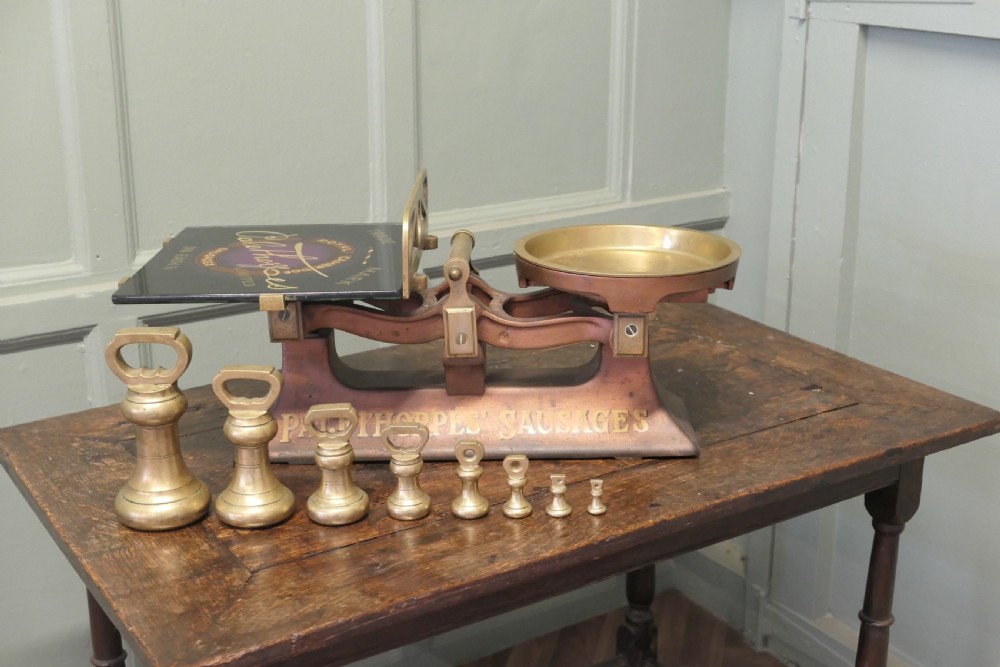 Antique cast iron and brass butcher balance scales with Palethorpes advertising print and a set of brass bell weights.