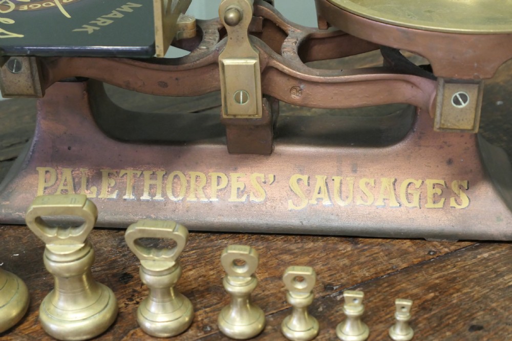 Antique cast iron and brass butcher balance scales with Palethorpes advertising print and a set of brass bell weights. View III
