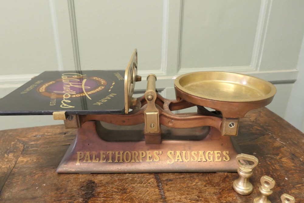 Antique cast iron and brass butcher balance scales with Palethorpes advertising print and a set of brass bell weights. View VI