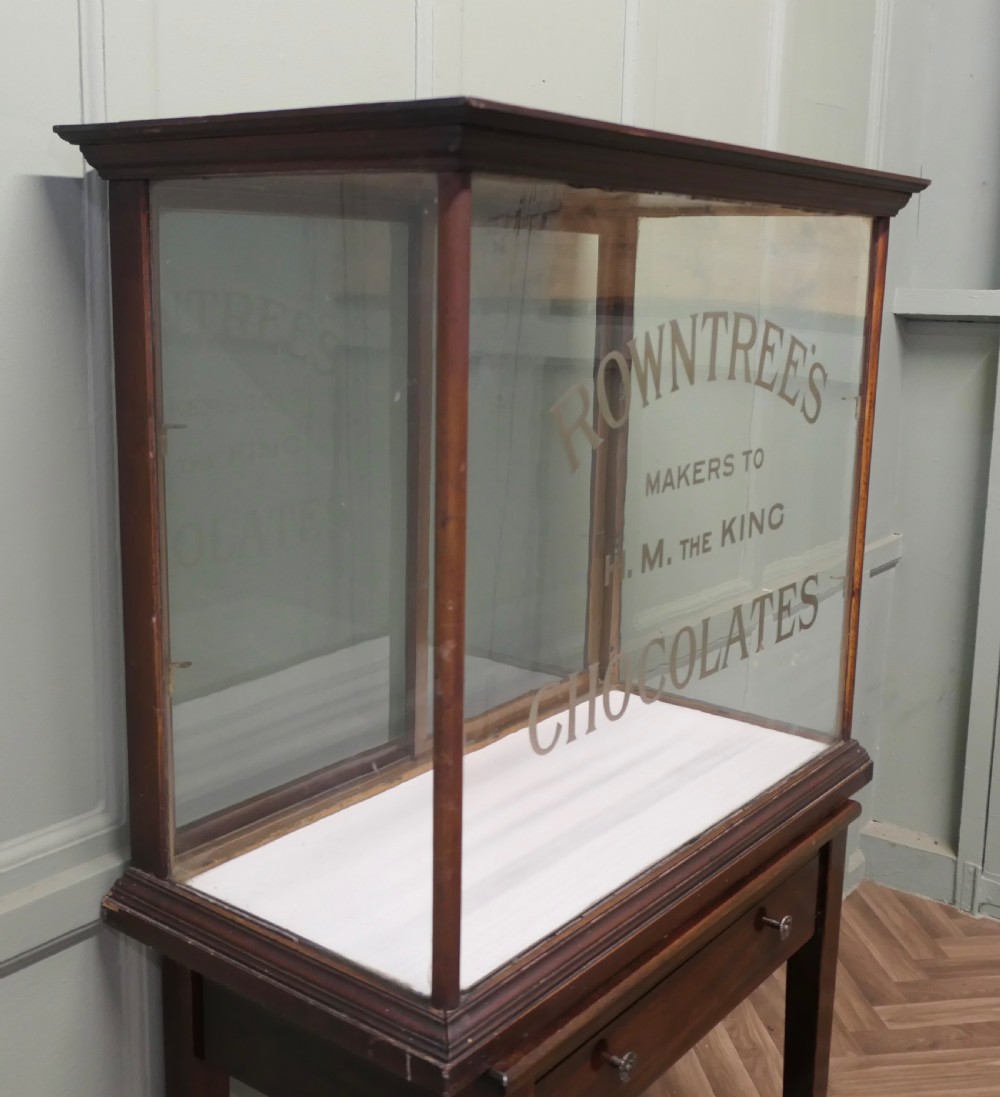 An Edwardian glazed mahogany shop display cabinet featuring gilded Rowntrees Chocolates lettering on the front glass panel.