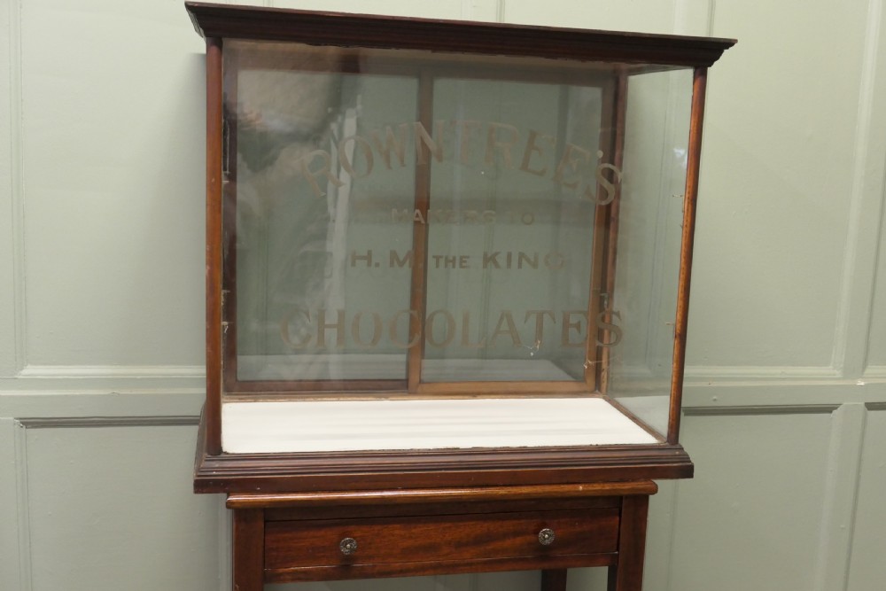 An Edwardian glazed mahogany shop display cabinet featuring gilded Rowntrees Chocolates lettering on the front glass panel. View III