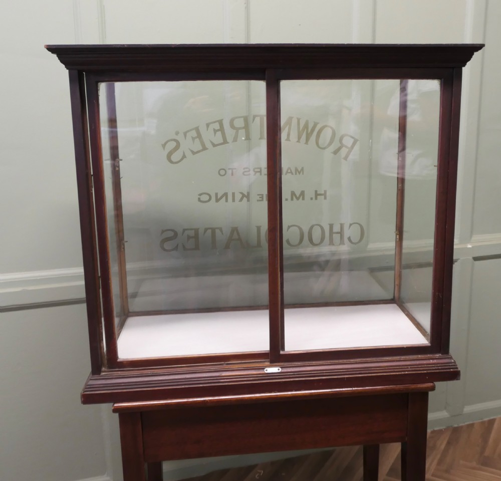 An Edwardian glazed mahogany shop display cabinet featuring gilded Rowntrees Chocolates lettering on the front glass panel. View VI
