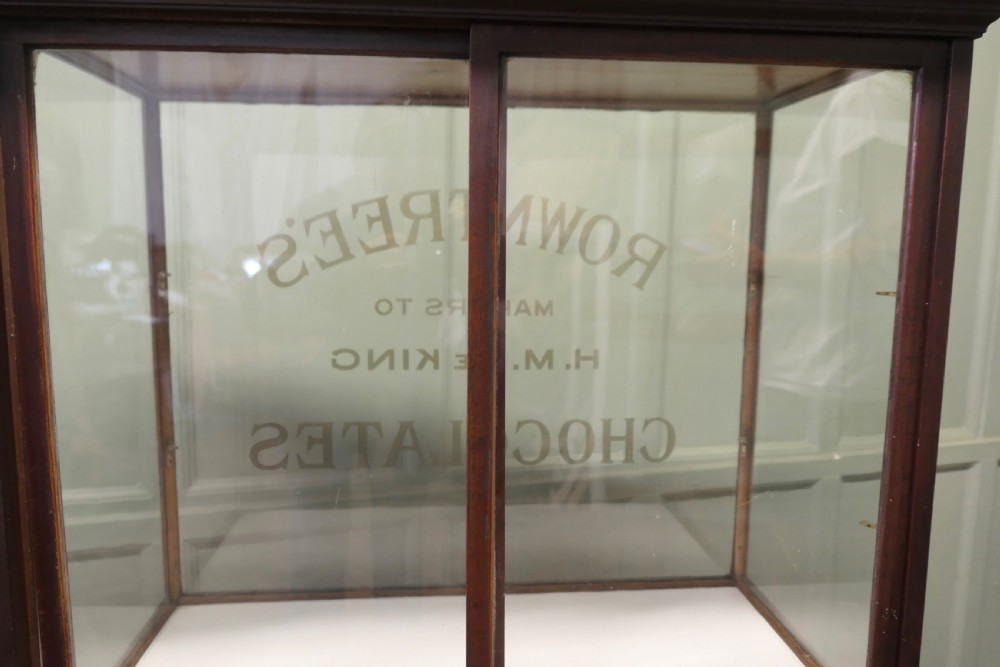 An Edwardian glazed mahogany shop display cabinet featuring gilded Rowntrees Chocolates lettering on the front glass panel. View VII