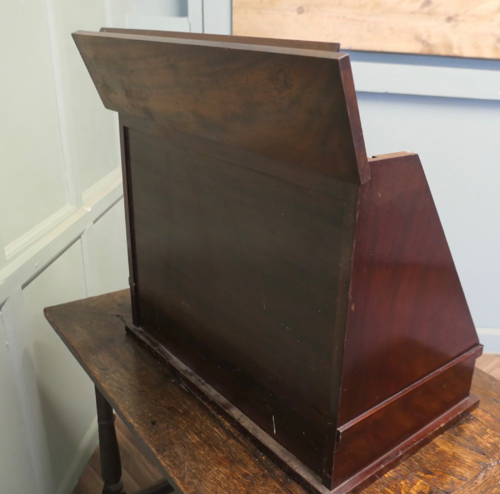 A nineteenth-century mahogany optician trial lens cabinet with a glass display door, brass fittings, and organized compartments containing optical test lenses. View II