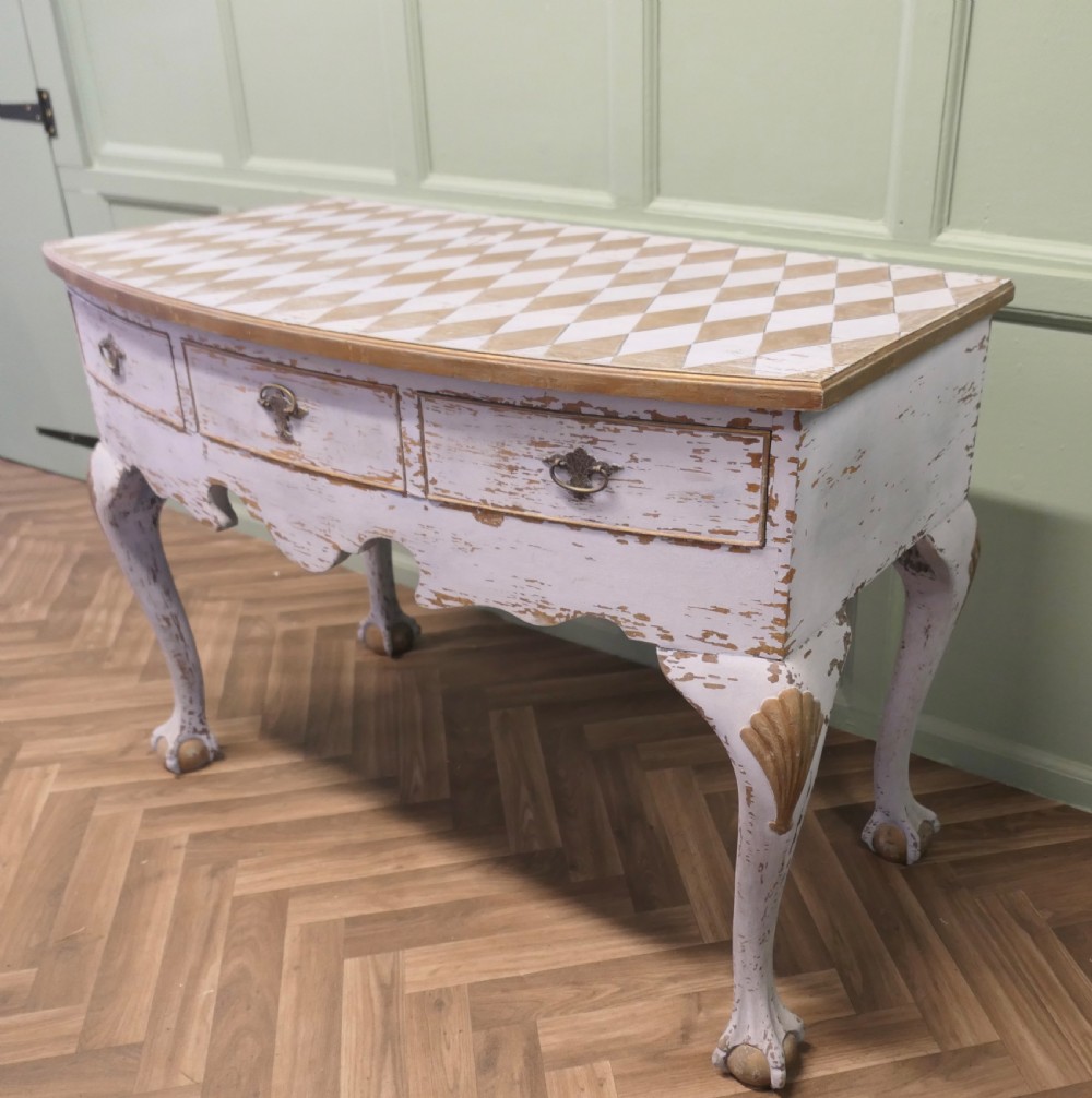 An eighteenth-century style painted bow-front console table featuring a diamond-pattern top, carved shell knees, claw-and-ball feet, and brass drawer handles. View VI