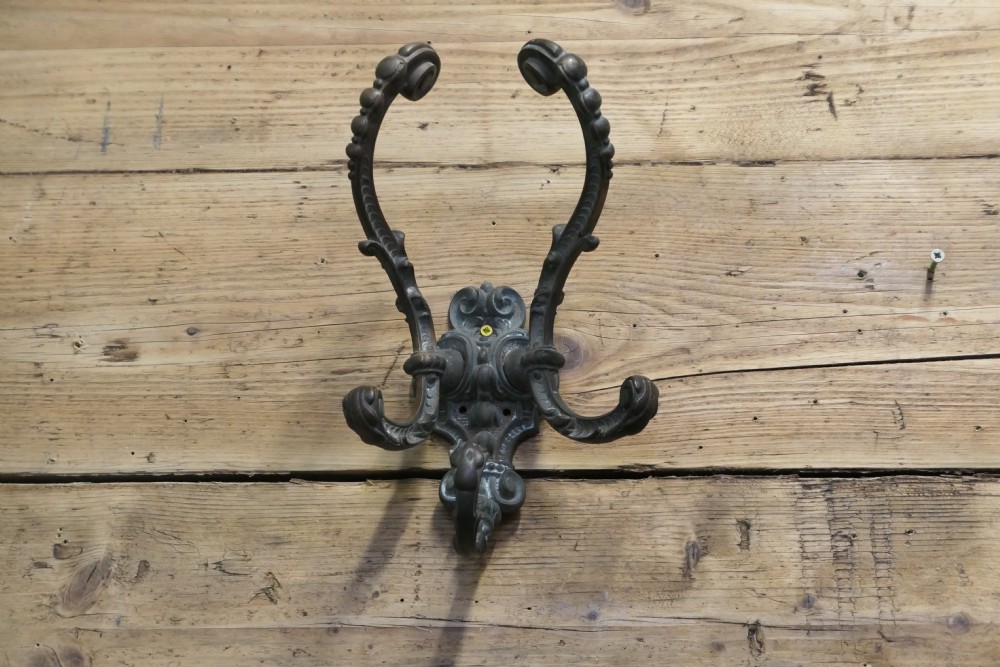 An early nineteenth-century ornate cast bronze hat and coat hook with scrolled detailing and a dark patinated finish.