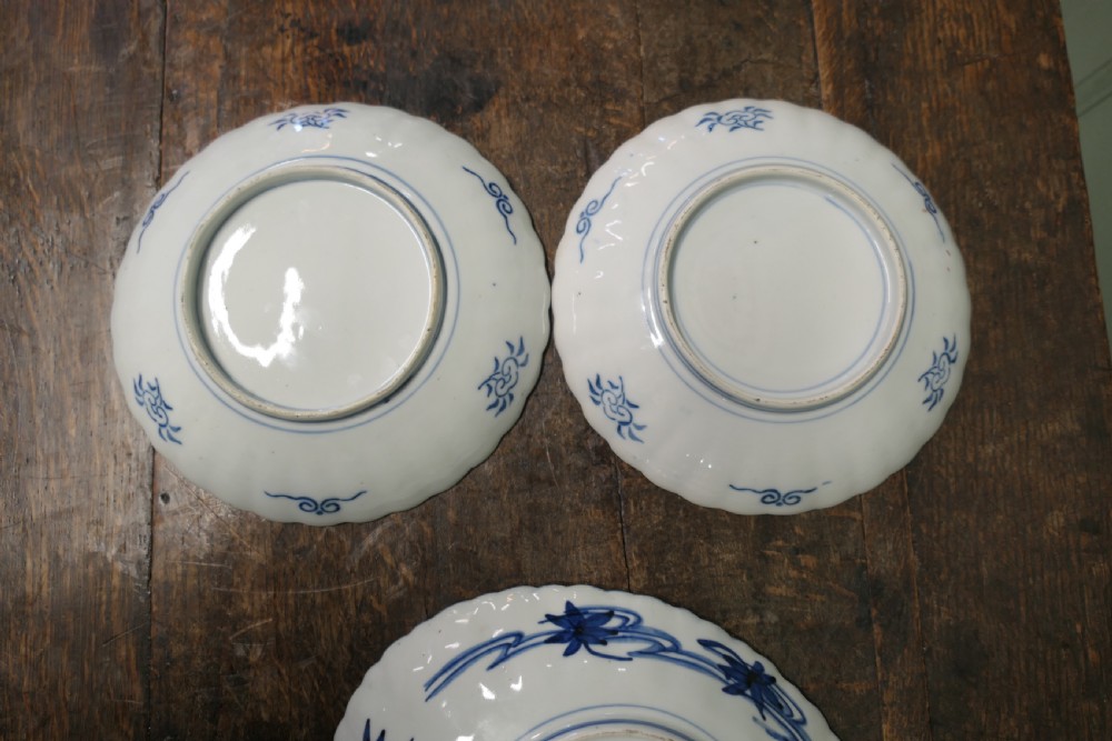A set of three 19th-century Imari ironstone ceramic plates featuring scalloped edges and hand-painted blue, terracotta, and white floral motifs. View VII