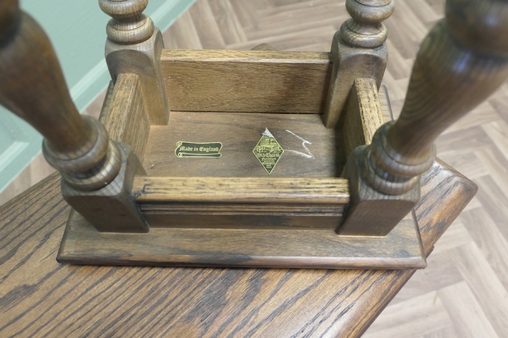 A set of three dark oak nesting side tables in graduated sizes featuring turned baluster legs and base stretchers. View VI