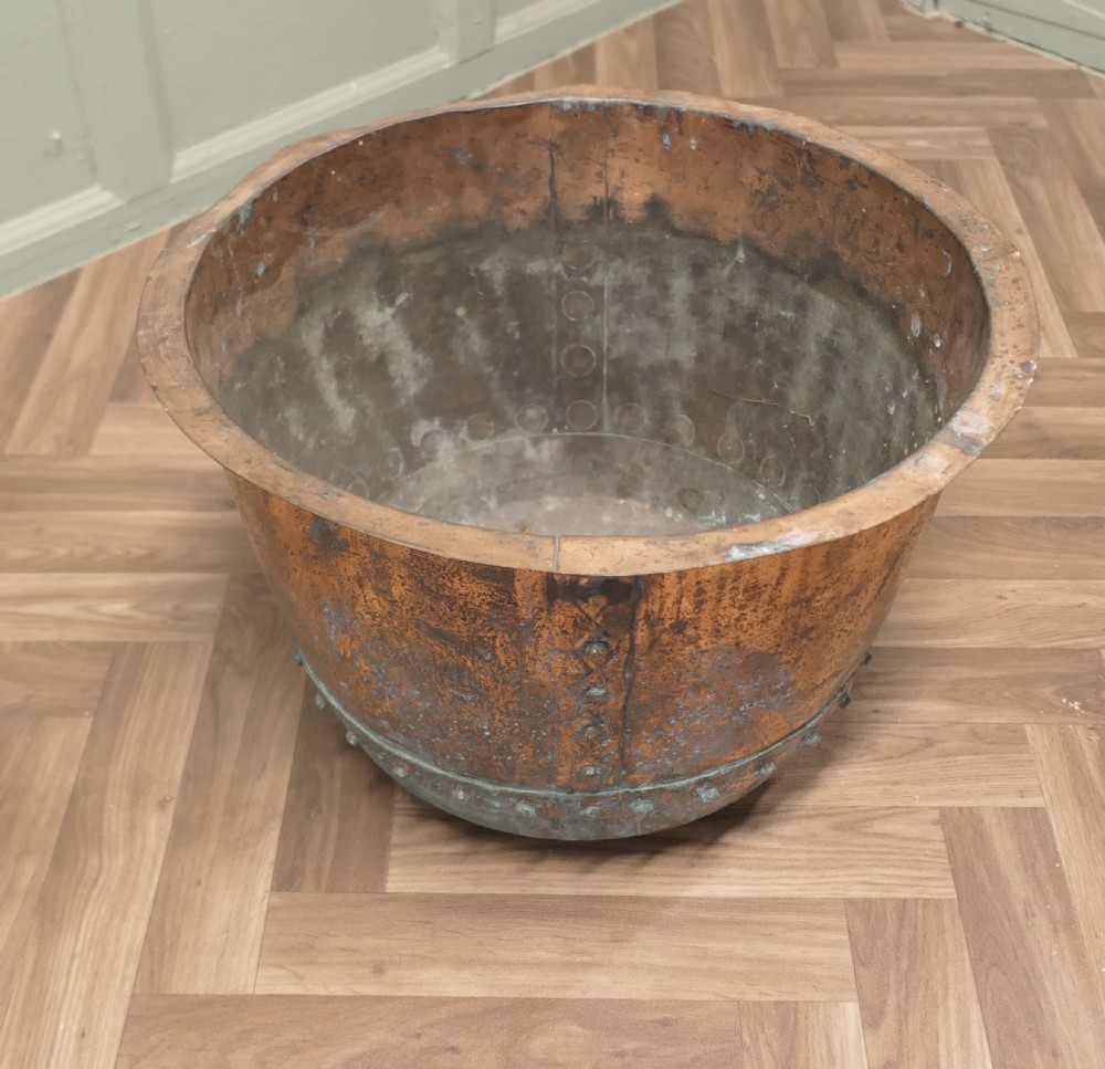 A 19th-century deep copper vessel featuring hand-riveted vertical and base seams with a wide flared rim and natural surface patina. View IV