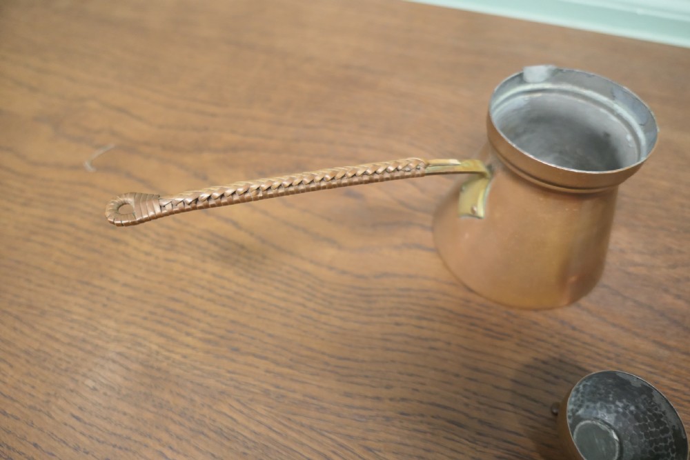 A hand-hammered copper pot featuring a long brass handle, pouring spout, and tin-lined interior. View III
