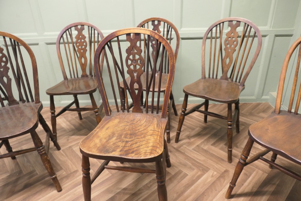 A harlequin set of six antique beech and elm wheelback Windsor dining chairs with turned legs and hoop backs. View II