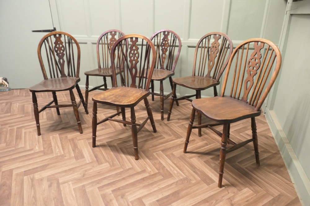 A harlequin set of six antique beech and elm wheelback Windsor dining chairs with turned legs and hoop backs. View III
