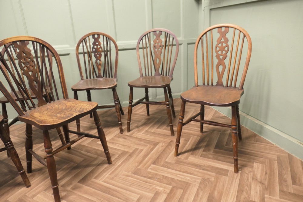 A harlequin set of six antique beech and elm wheelback Windsor dining chairs with turned legs and hoop backs. View IV