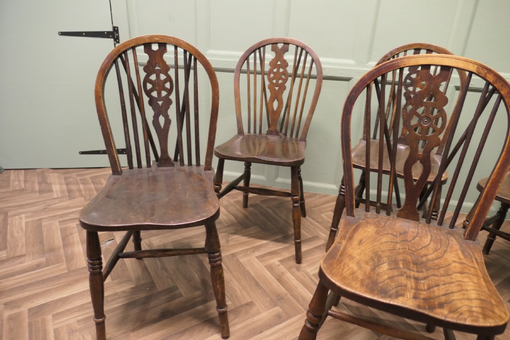 A harlequin set of six antique beech and elm wheelback Windsor dining chairs with turned legs and hoop backs. View V