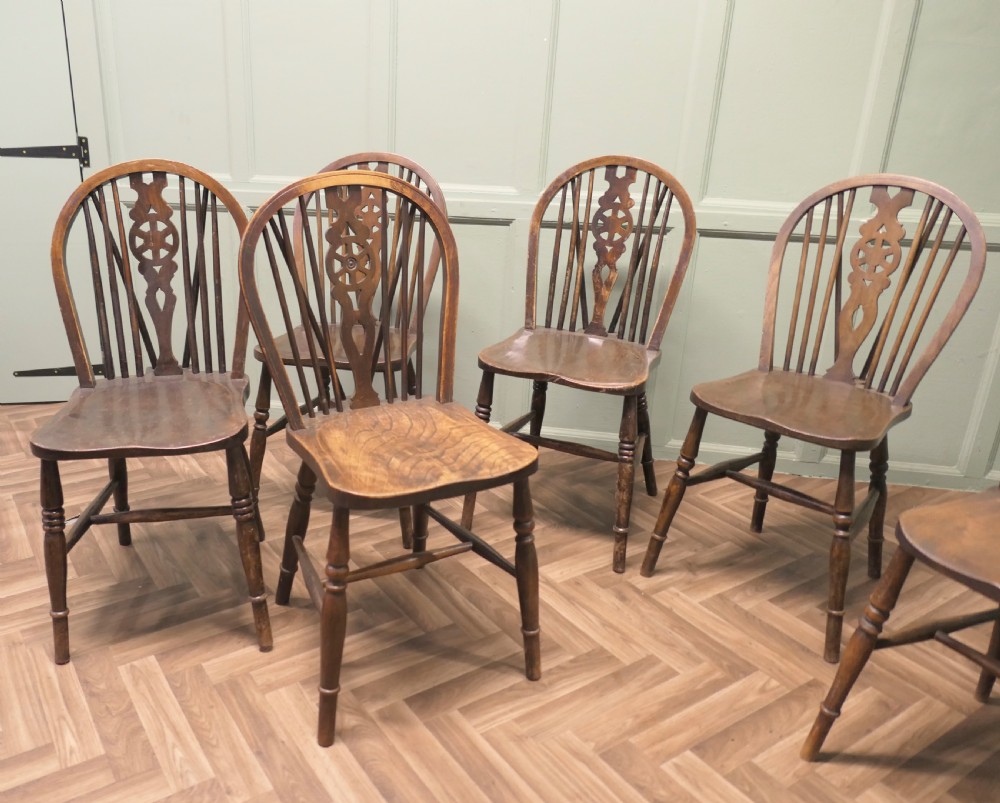 A harlequin set of six antique beech and elm wheelback Windsor dining chairs with turned legs and hoop backs. View VI