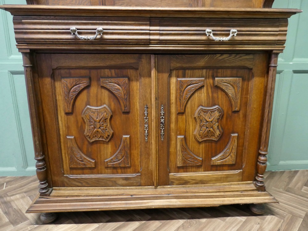 A two-tier carved oak French buffet de corps featuring a central high-relief panel depicting a hunting scene, spindled top gallery, and two-door lower base. View III