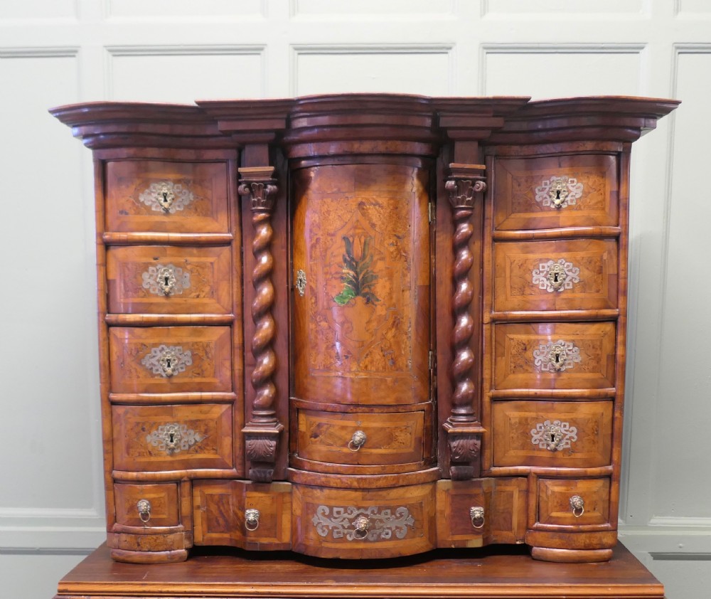 A Baroque burr walnut tabletop escritoire cabinet with a central revolving tabernacle flanked by barley-twist columns and small side drawers.