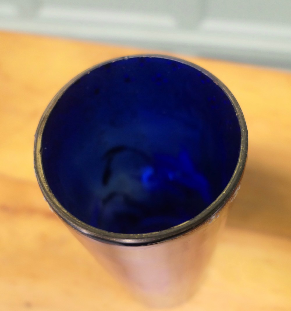 A tall cylindrical cobalt blue glass vase featuring enamelled white daffodils and a gilded lattice rim. View V