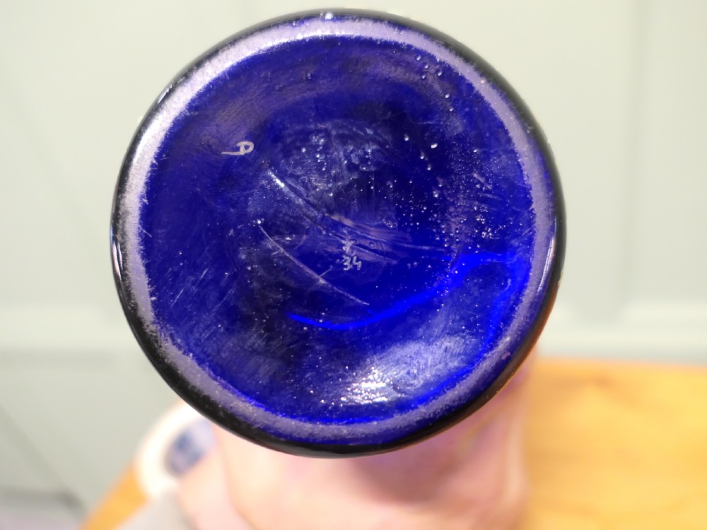 A tall cylindrical cobalt blue glass vase featuring enamelled white daffodils and a gilded lattice rim. View VII
