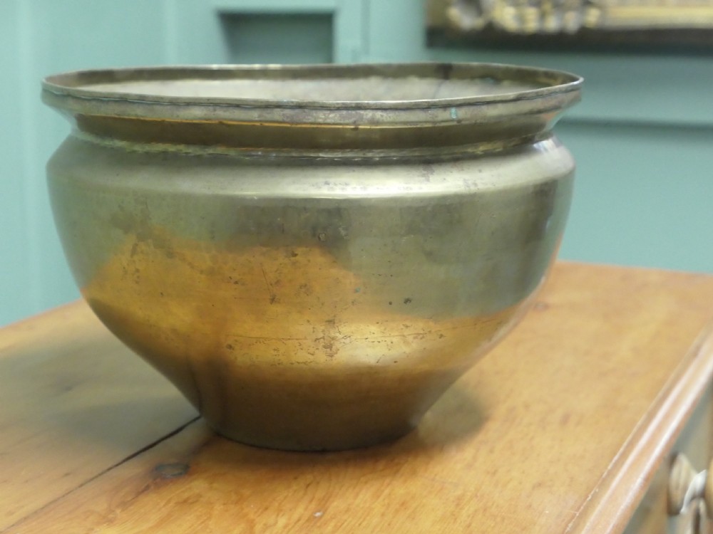 A nineteenth-century brass planter featuring a rounded bulbous body, narrow base, and flared rim with natural surface patination. View V