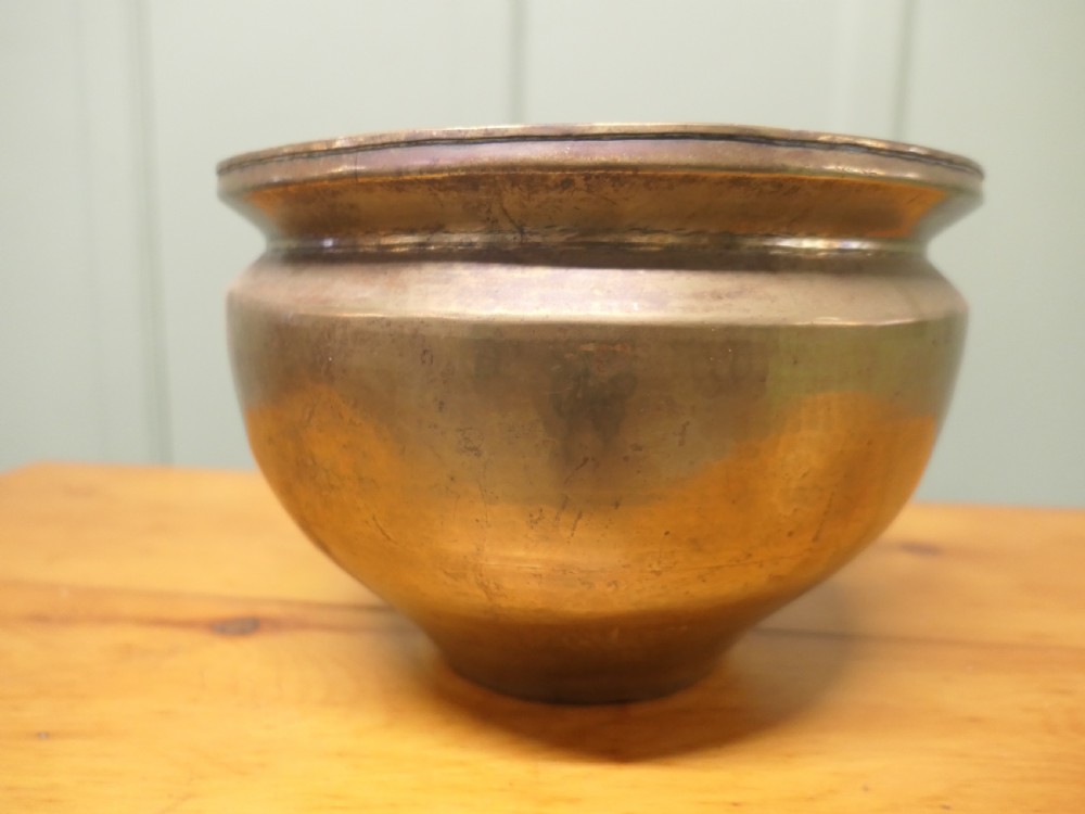 A nineteenth-century brass planter featuring a rounded bulbous body, narrow base, and flared rim with natural surface patination. View VI