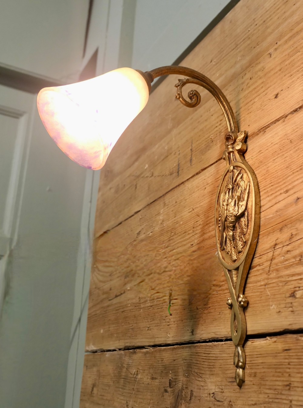 A French cast brass wall light featuring a decorative backplate, curved gooseneck arm, and bell-shaped mottled glass shade. View II