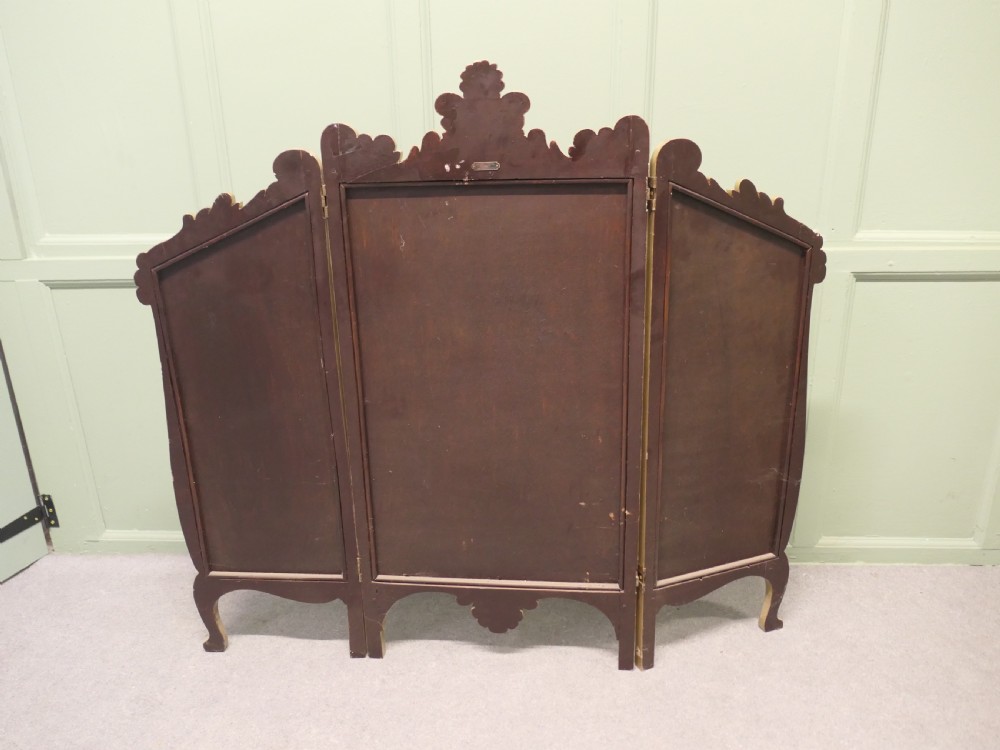 A three-panel folding fire screen with a carved gold giltwood frame and oil-painted maritime scenes depicting ships near a coastal shore at sunset. View II
