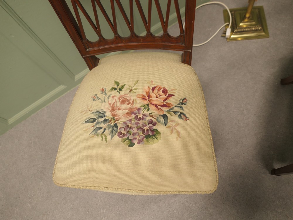 A pair of antique walnut hall chairs with lattice openwork backs and floral needlepoint upholstered seats. View II