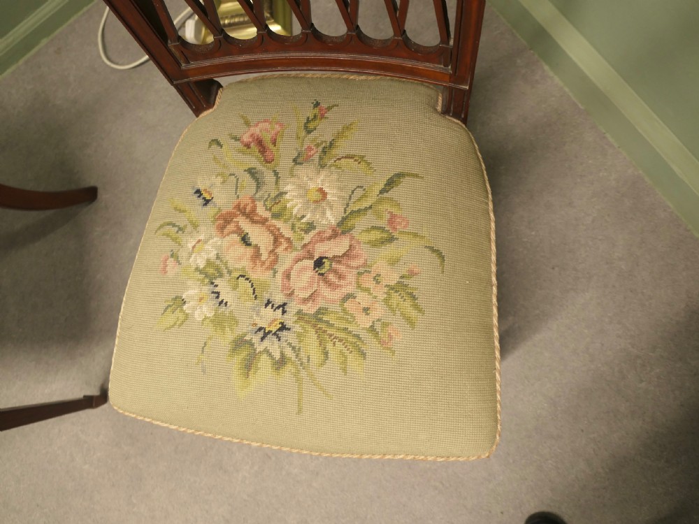 A pair of antique walnut hall chairs with lattice openwork backs and floral needlepoint upholstered seats. View V