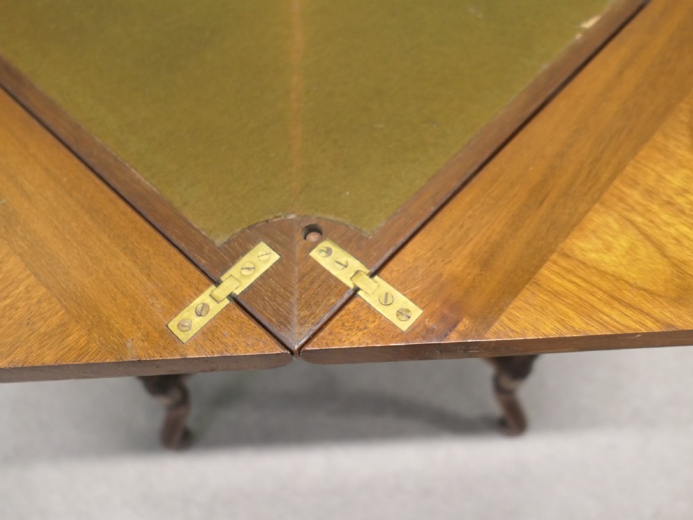A late Victorian mahogany envelope card table with four triangular flaps unfolding to reveal a central green baize surface and four circular counter wells. View V