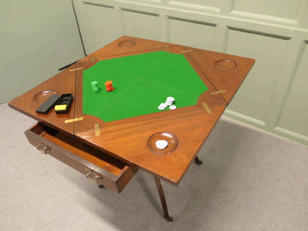 A Victorian mahogany envelope card table featuring four triangular folding top leaves, a single drawer with brass handles, and a turned central pedestal on four splayed legs with castors. View IV