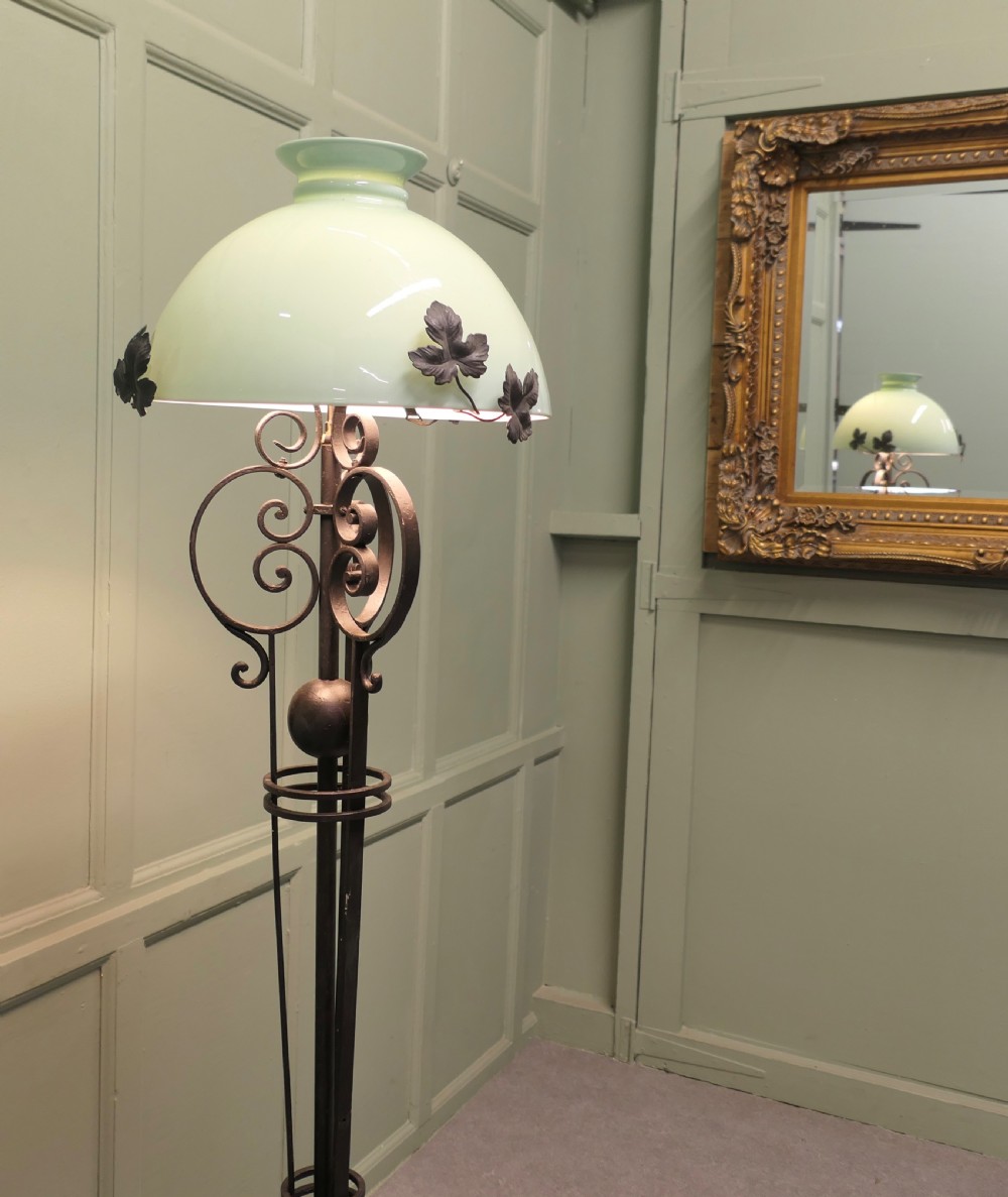 A tall French wrought iron floor lamp with a scrolling tripod base, leaf details, and a pale green dome glass shade. View II