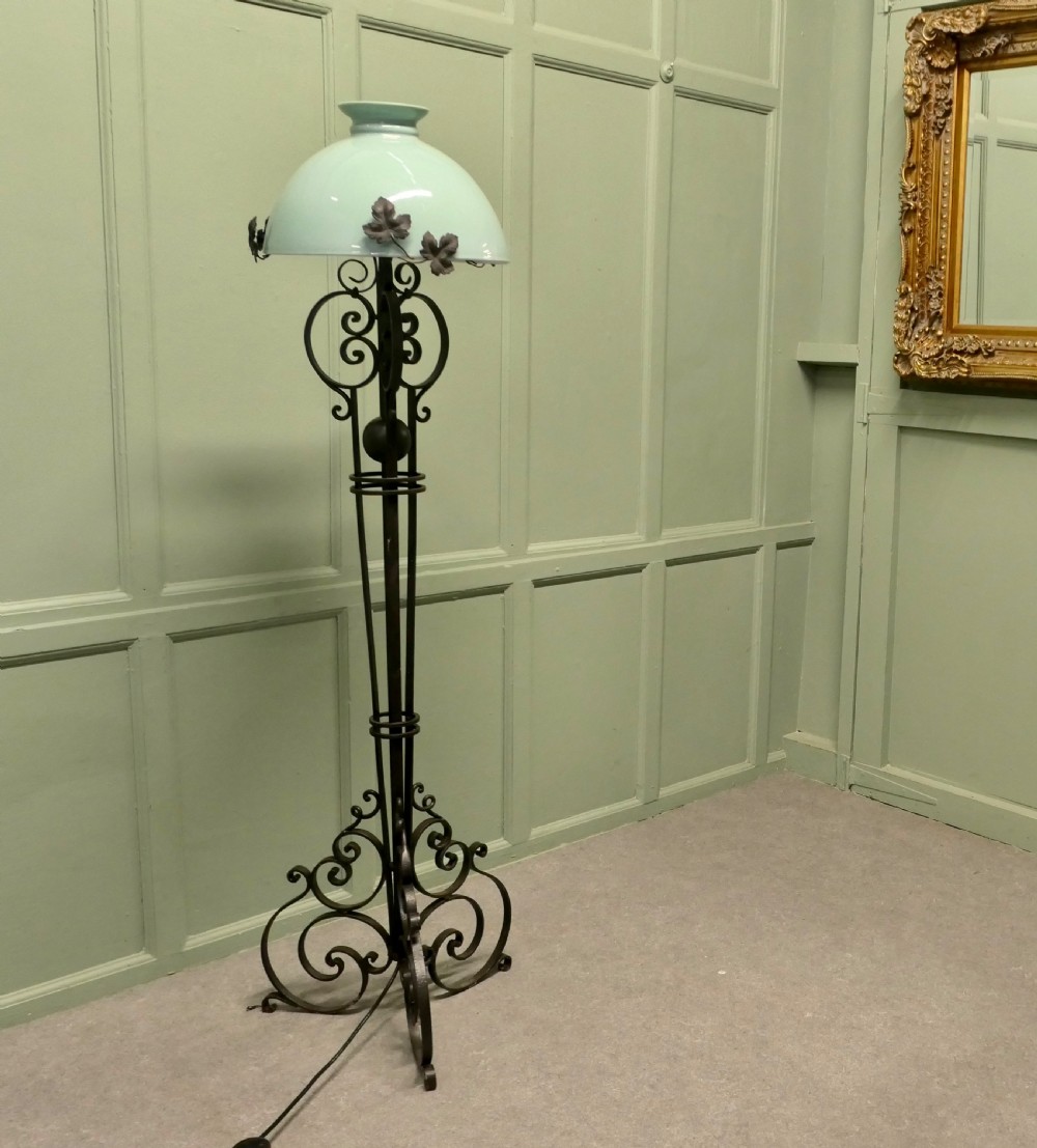 A tall French wrought iron floor lamp with a scrolling tripod base, leaf details, and a pale green dome glass shade. View III