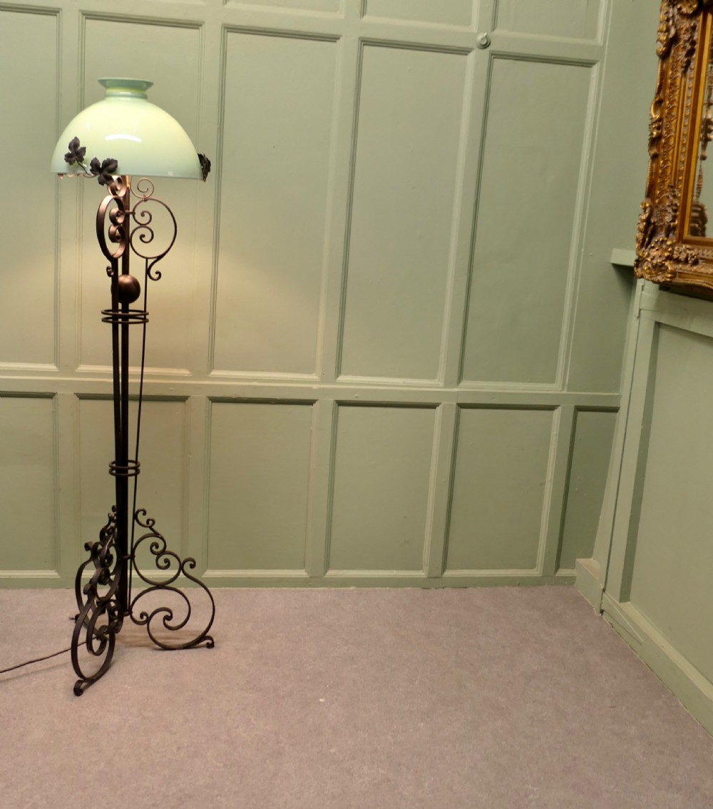 A tall French wrought iron floor lamp with a scrolling tripod base, leaf details, and a pale green dome glass shade. View IV