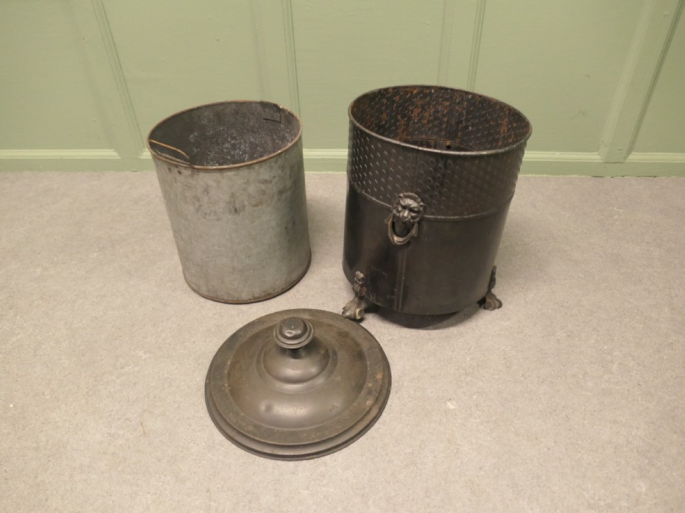 A dark patinated metal cylindrical coal bucket featuring a stepped lidded top with an urn finial, a diamond lattice pattern band, side handles, and cast feet. View III