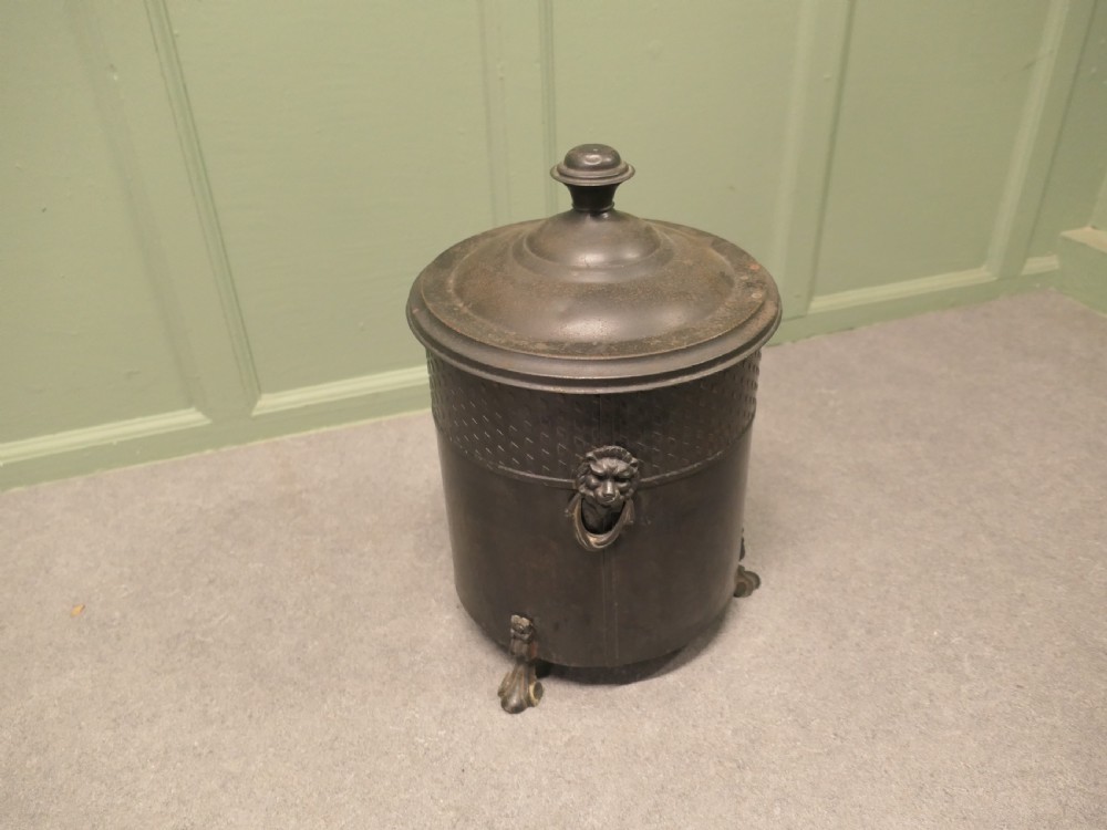 A dark patinated metal cylindrical coal bucket featuring a stepped lidded top with an urn finial, a diamond lattice pattern band, side handles, and cast feet. View IV