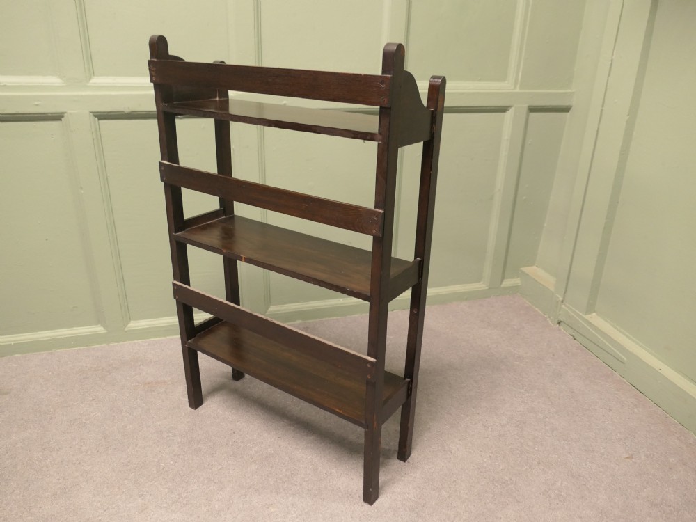 A dark oak three-shelf open bookcase with shaped side profiles and horizontal support rails. View II